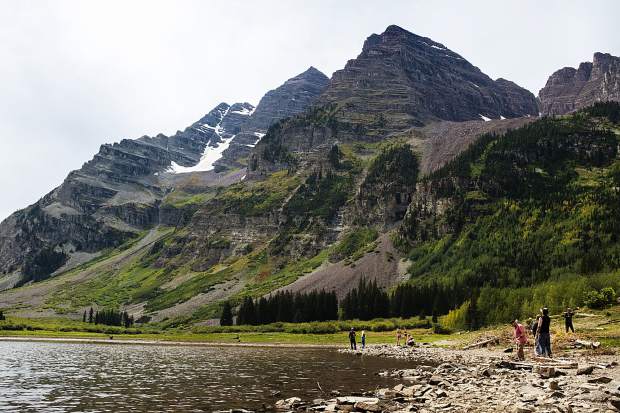 People mill around Crater Lake after reaching the end of the Crater Lake Trail near Aspen on Sunday. Leaves have been slow to turn in the Maroon Lake Scenic Area this late summer.